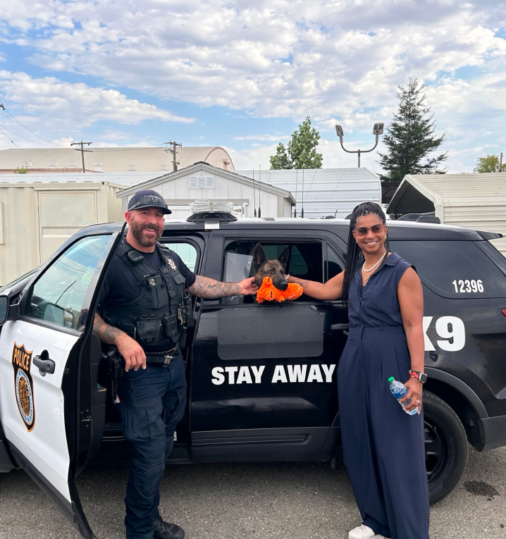 officer and a person petting a dog in the officers vehicle