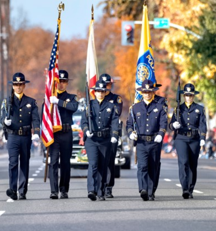 officers walking down a road with flags